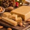 Turrón blando casero de almendra y miel en trozos sobre una tabla de madera
